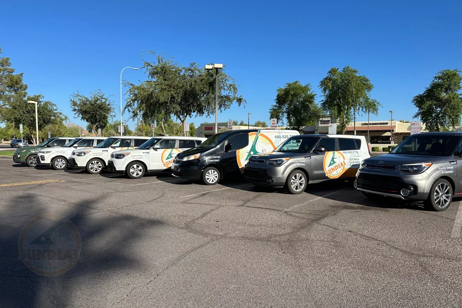 A line-up of vehicles with 'SUNDIAL LOCKSMITH' branding.