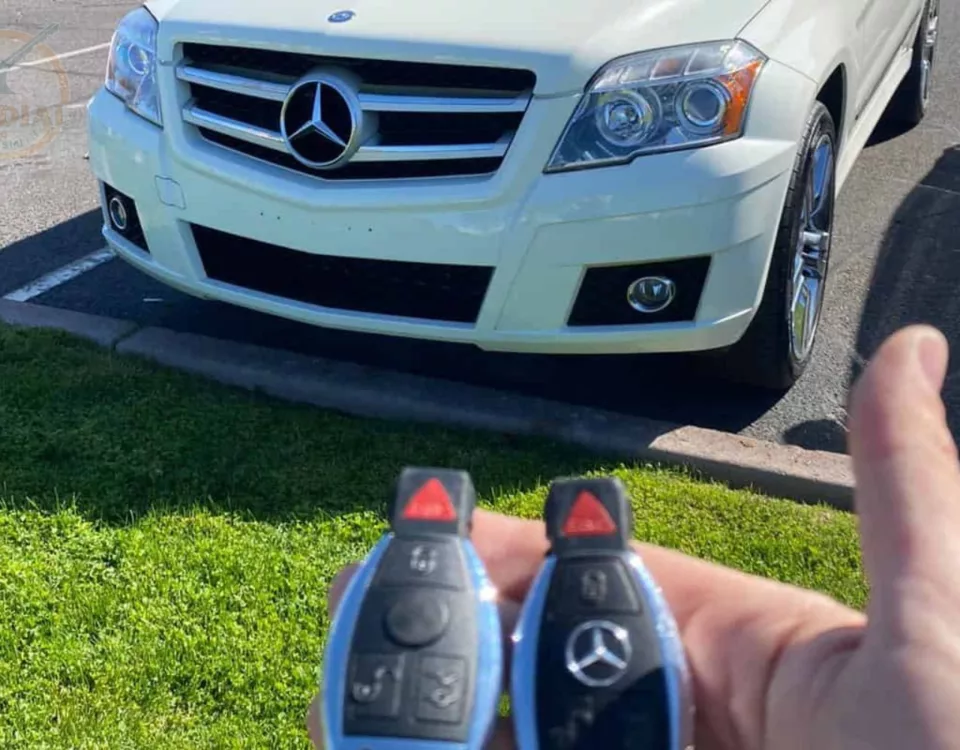 Holding car keys in front of a white Mercedes-Benz.
