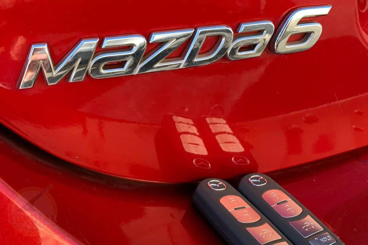 Red Mazda6 car logo with key fobs.