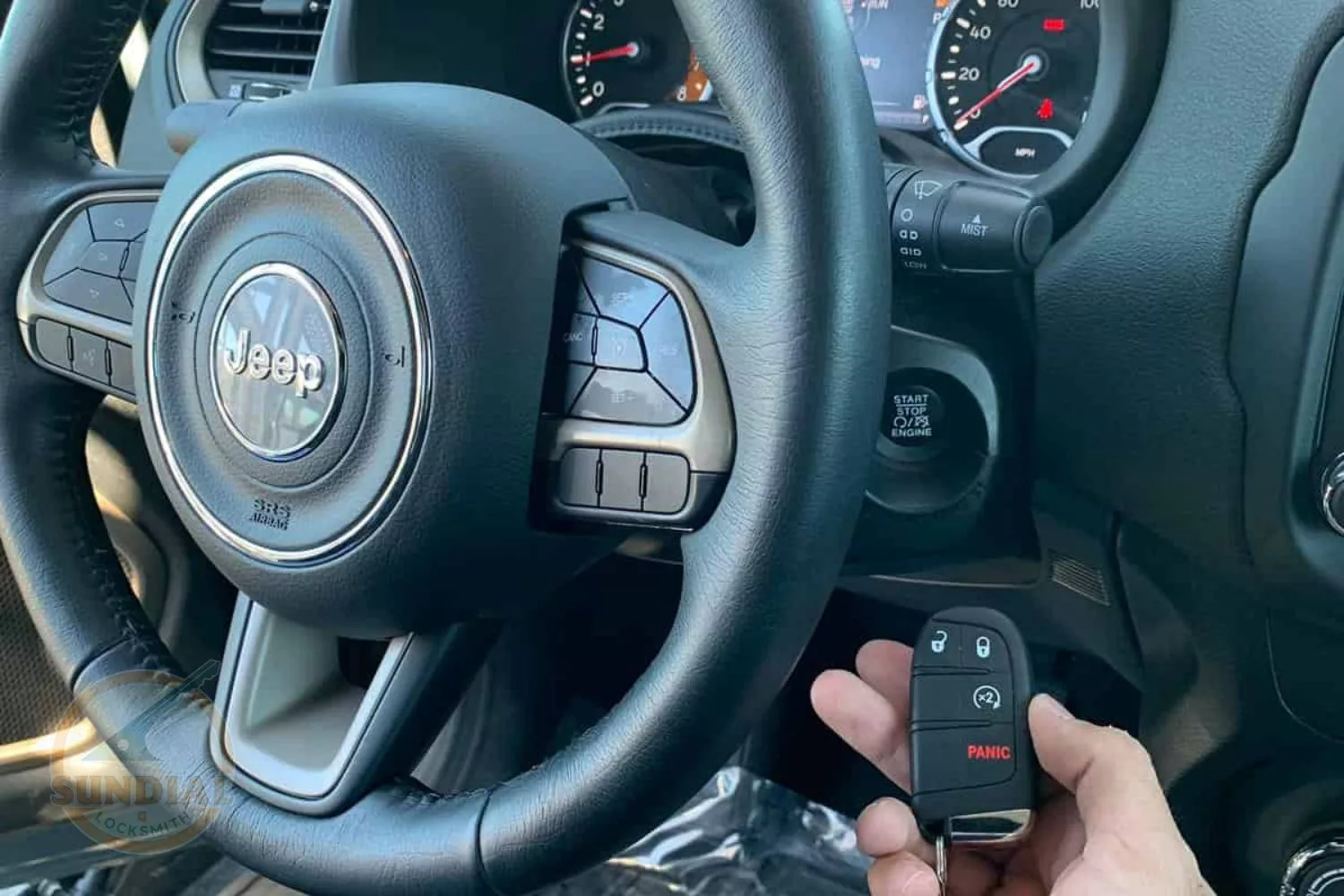 Jeep steering wheel and key fob in hand.
