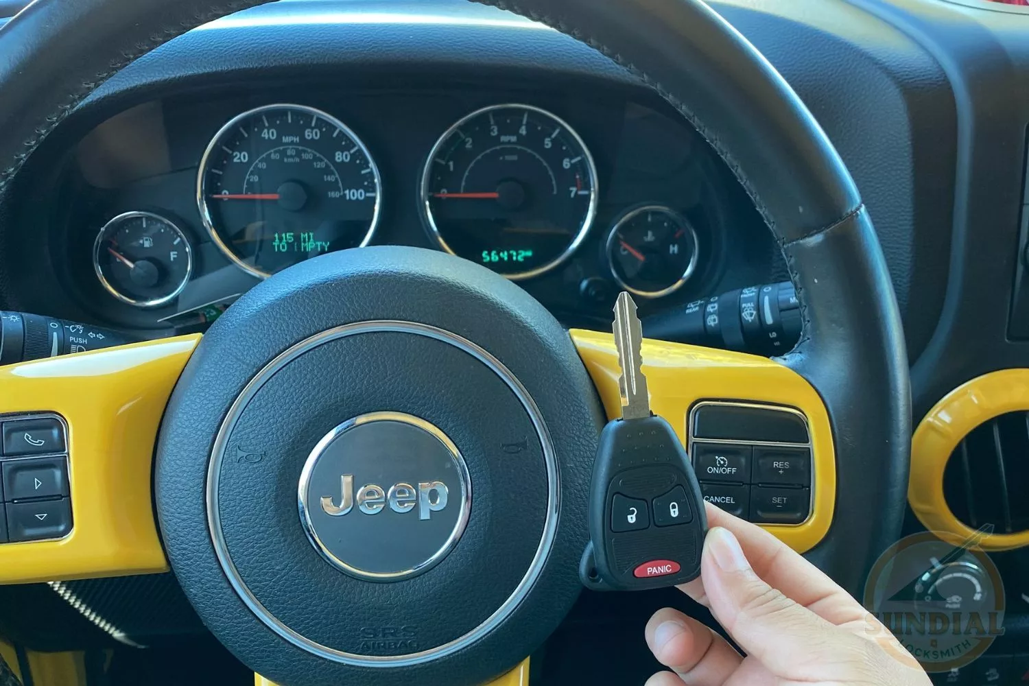 Jeep dashboard with key fob and steering wheel.