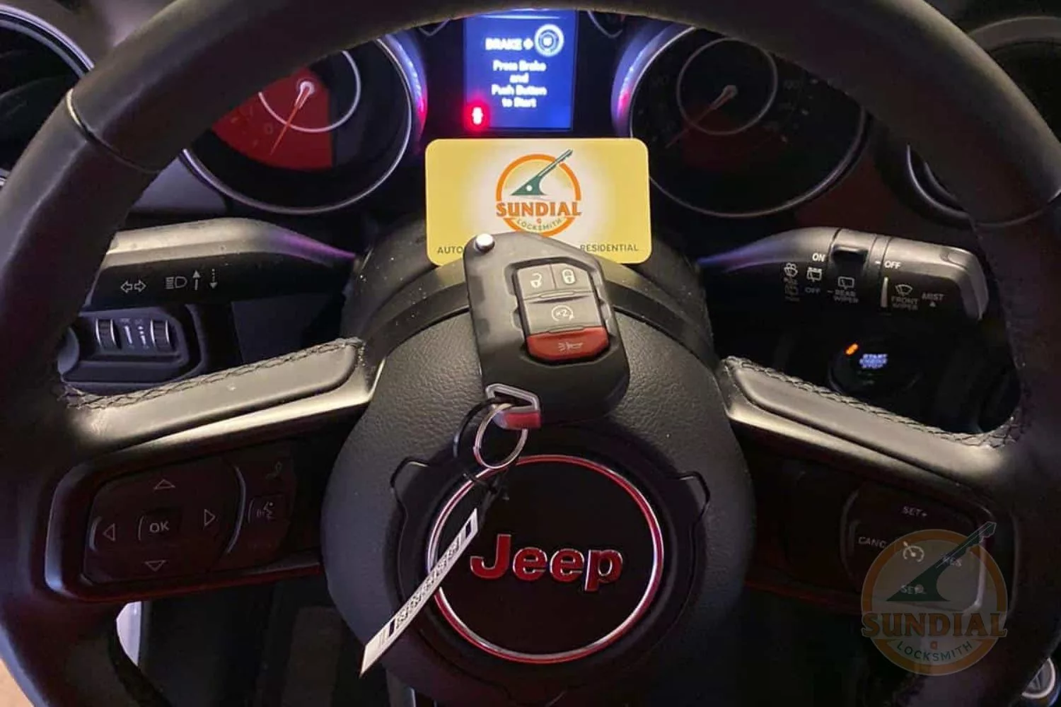 Jeep car key on steering wheel with access card.