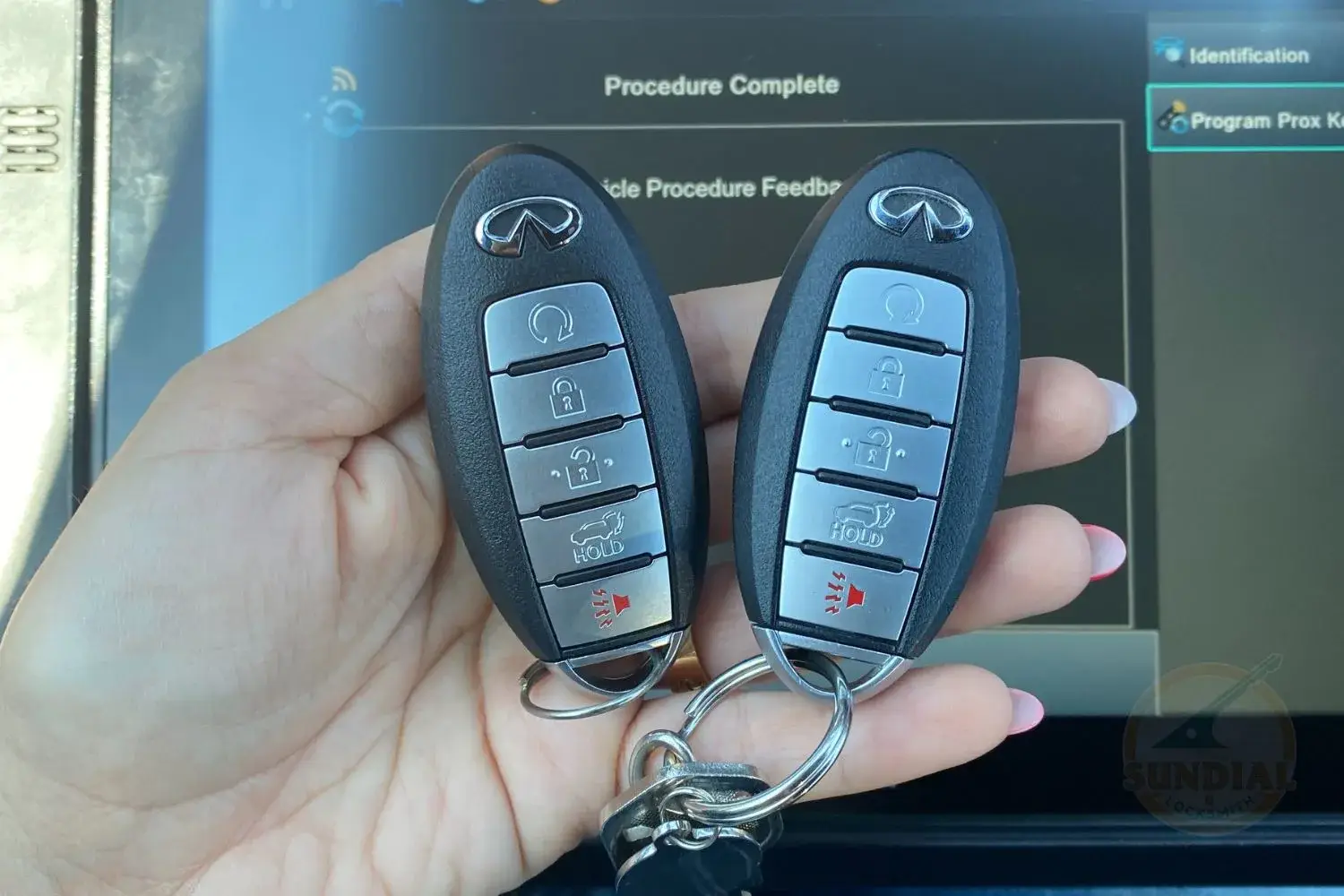 Two car key fobs held in hand.