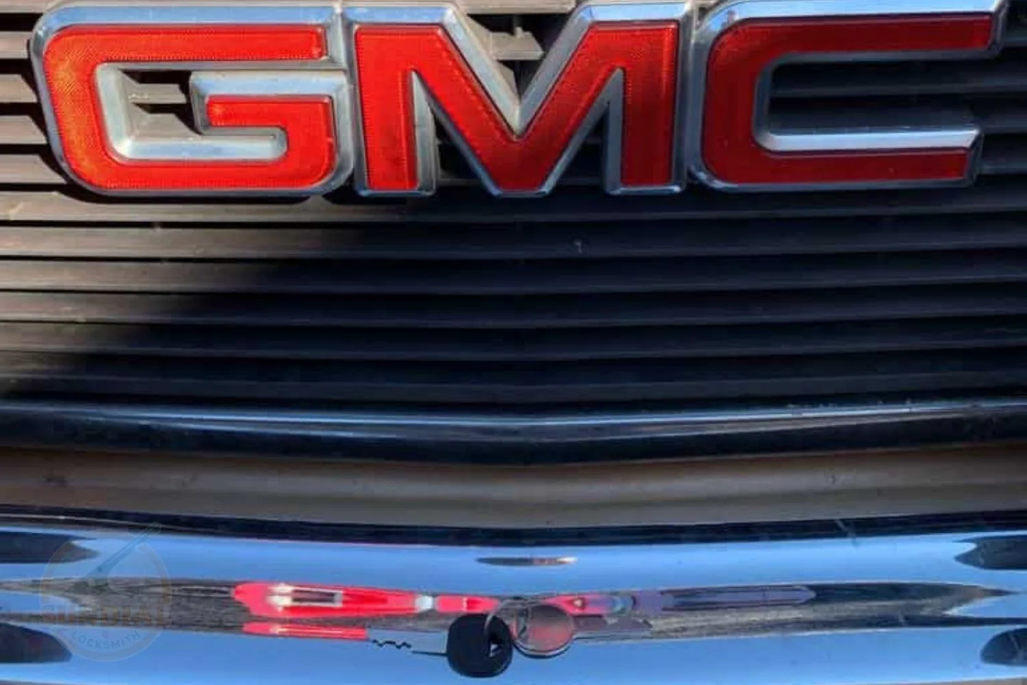 Close-up of GMC vehicle grille emblem.