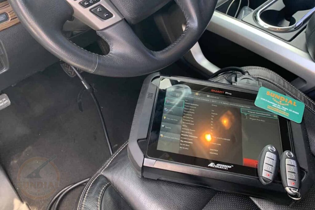 Rekeying After a Divorce or Separation: Why It's One of the First Things You Should Do A diagnostic tablet and programmer device displaying software on a car's front seat next to a steering wheel and a set of car key fobs.