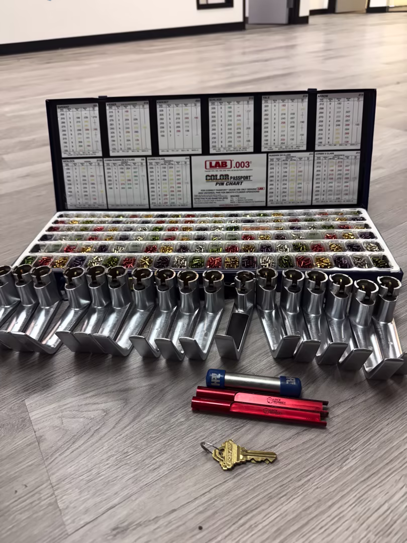Can You Rekey a Lock to Match an Existing Key You Already Carry? A locksmith performing lock rekeying to existing key on a residential front door in , with pin kit tools laid out neatly on a work mat