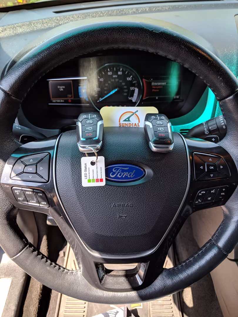 A locksmith for Ford Explorer programming a replacement key fob using professional diagnostic equipment connected to a Ford Explorer in a sunny Arizona parking area